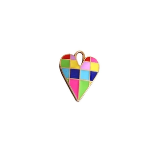 Macro shot of colorful checkered heart pendant with gold-plated geometric enamel mosaic