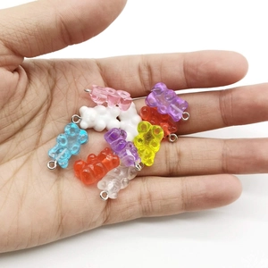 Close-up of assorted colorful resin bear pendants held in hand for DIY jewelry making