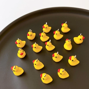 Detail of yellow resin duck pendants with silver metal rings for DIY jewelry crafting