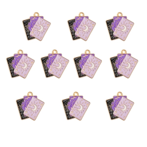 Close-up of alloy tarot pendants with purple enamel cat designs and golden metal frames