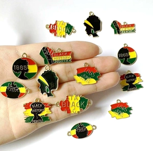 Macro detail of Juneteenth alloy enamel pendants in vibrant red, yellow, and green colors