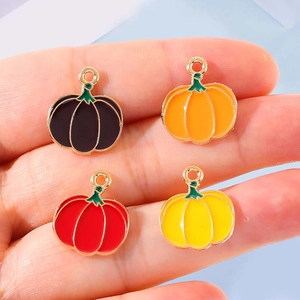 Bunte Emaille-Kürbisanhänger in vier Farben in der Hand für Schmuck-DIY
