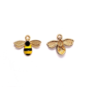 Detalle frontal y posterior de colgantes de abeja esmaltada para hacer bisutería