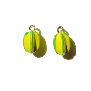 Macro detail of yellow starfruit charms with green edges and gold rings for DIY jewelry
