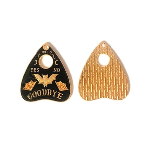 Makro-Detail von Gothic Ouija-Anhängern mit schwarzer Emaille und goldenen Spinnennetzen