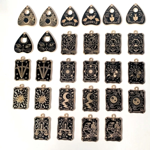 Nahaufnahme verschiedener gotischer Tarotkarten-Anhänger und Planchette-Emaille-Anhänger