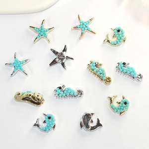 Detailed close-up of blue beaded starfish, seahorse and dolphin DIY ocean charms
