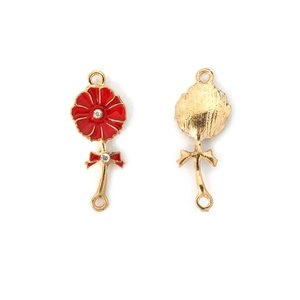 Detail view of red enamel cherry blossom pendant with white rhinestones and gold bow