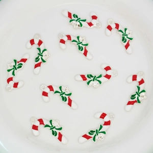 Detail of candy cane charms with red white stripes and green bow for DIY jewelry making