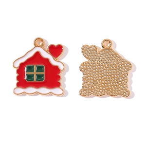 Macro view of Christmas house alloy charms with red enamel and white snow details for DIY