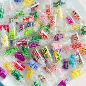 Macro shot of colorful miniature fruit slices and star glitters in small DIY glass bottles