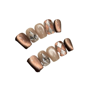 Unghie finte cat eye marroni con motivi a rombi e strass 3D su sfondo bianco
