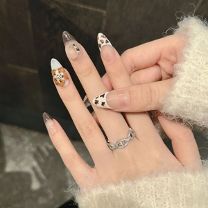 3D floral press-on nails with leopard print and heart motifs worn with silver chain ring