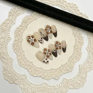 Handmade press-on nails with 3D floral art, brown French tips, and pearl accents