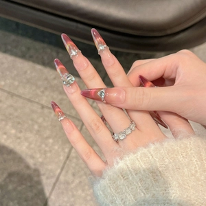 Faux ongles stiletto oeil de chat rouge grenade avec strass luxueux et effet dégradé