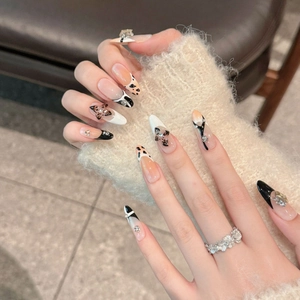 Handmade almond press-on nails featuring 3D bow, rhinestones and black-white French tips