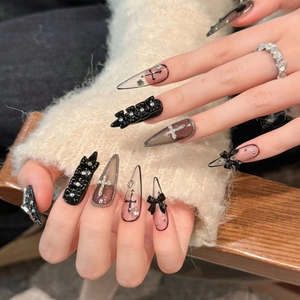 Faux ongles faits main style gothique stiletto avec nœuds noirs et charmes de croix