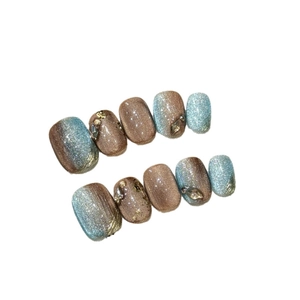 Cat eye press-on nails set in blue and brown with gold foil and rhinestone accents