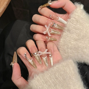 Champagne gold cat eye press-on nails with white French tips and 3D ribbon bows