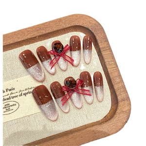 Cat eye press-on nails in cherry red gradient with 3D organza bow and gemstone accents