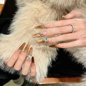 Brown cat eye press-on stiletto nails with sparkling crystals and diamonds on fur background