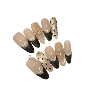 Elegant almond press-on nails with black polka dots and gold glitter champagne gradient