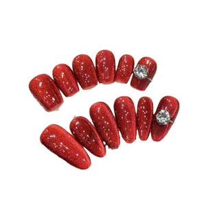 Red glitter cat-eye press-on nails set with rhinestones in oval and coffin shapes