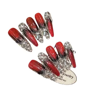 Red and black cat eye press-on nails with luxury rhinestones in long almond shape
