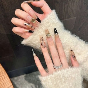 Cat eye press-on nails with black gold gradient and gemstone accents in long stiletto shape