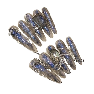 Faux ongles stiletto faits main avec paillettes œil de chat bleu et bijoux 3D