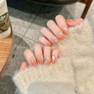 Pink cat-eye press-on nails with silver flower accents and soft gradient finish