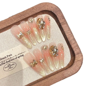 Faux ongles stiletto dégradés pailletés avec papillons dorés et pierres ambrées