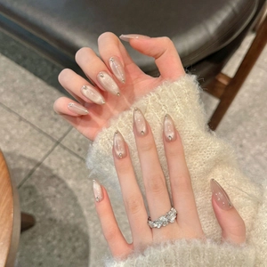 Nude cat-eye press-on nails in long almond shape with silver rhinestone accents