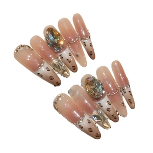 Extra long pointed press-on nails with leopard patterns and champagne oval rhinestones