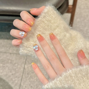 Peach gradient press-on nails with gold glitter and 3D floral accents in short square shape