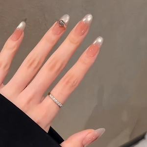 Elegant cat eye press-on nails in nude pink gradient with a 3D crown jewel accent
