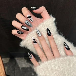 Dark aesthetic black and silver almond press-on nails with cat eye effect and rhinestone