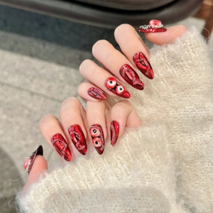Gothic dark red press-on nails with 3D eyeball details and metal chains on almond shape