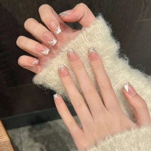 Handmade cat-eye press-on nails in nude pink french style with silver glitter accents