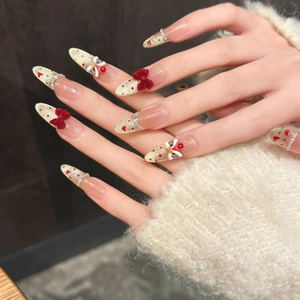 Unghie finte stiletto glitter oro con fiocco rosso e decorazione danza del leone