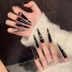 Gothic stiletto press-on nails with black evil eye pattern and silver metallic accents