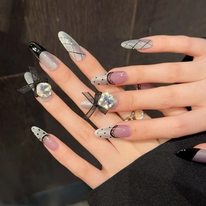 Gray cat eye press-on nails with black lace patterns and ribbon bow jewelry accents