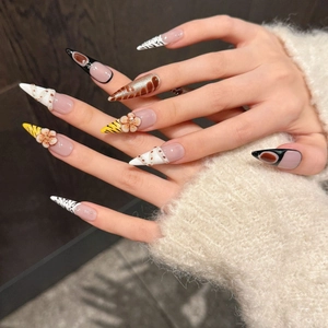 Long stiletto press-on nails featuring hand-carved floral patterns and wild animal prints