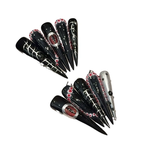 Gothic style extra long stiletto press-on nails with black demonic eye and metal designs