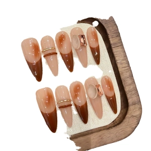 Brown and nude almond press-on nails with metallic accents and 3D gemstones