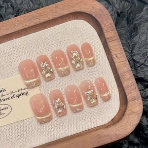 Faux ongles faits main œil de chat champagne avec feuilles d'or et lignes françaises