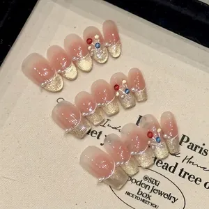 Pink cat eye press-on nails with champagne shimmer, pearls and colorful bead accents