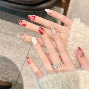 Handmade cat-eye press-on nails with red floral patterns and glossy champagne finish
