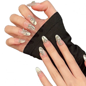 Faux ongles faits main effet œil de chat nacré avec papillon argenté et accents de perles
