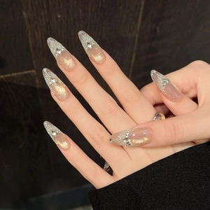 French almond press-on nails with pink cat eye effect and rhinestone tassels